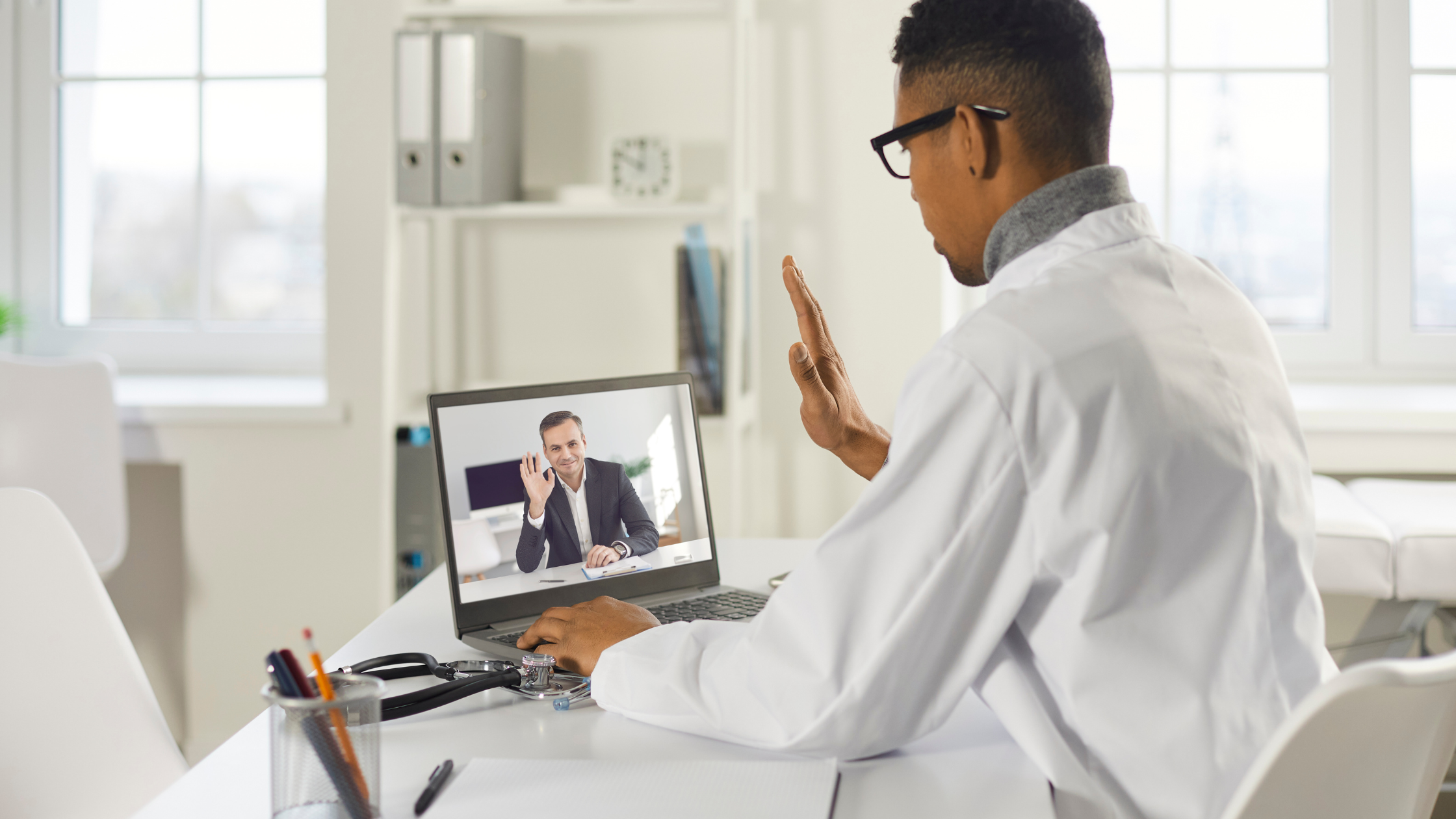 Doctor at his laptop on a video conference call with a patient.